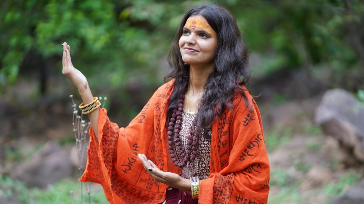 Arassoc A woman in traditional attire meditating peacefully in a natural setting.